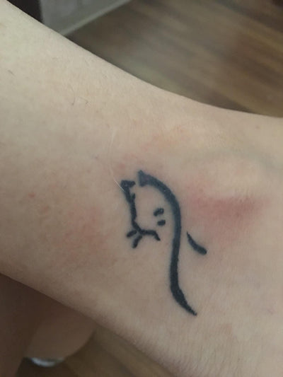 Healed Small black tattoo in a person's feet