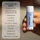 Hand holding an Ear grey lip balm with a list of ingredients on a blurred background.