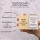 Soothing Suds Oatmeal soap bar with packaging held by a hand, labeled with ingredients on a marble background.