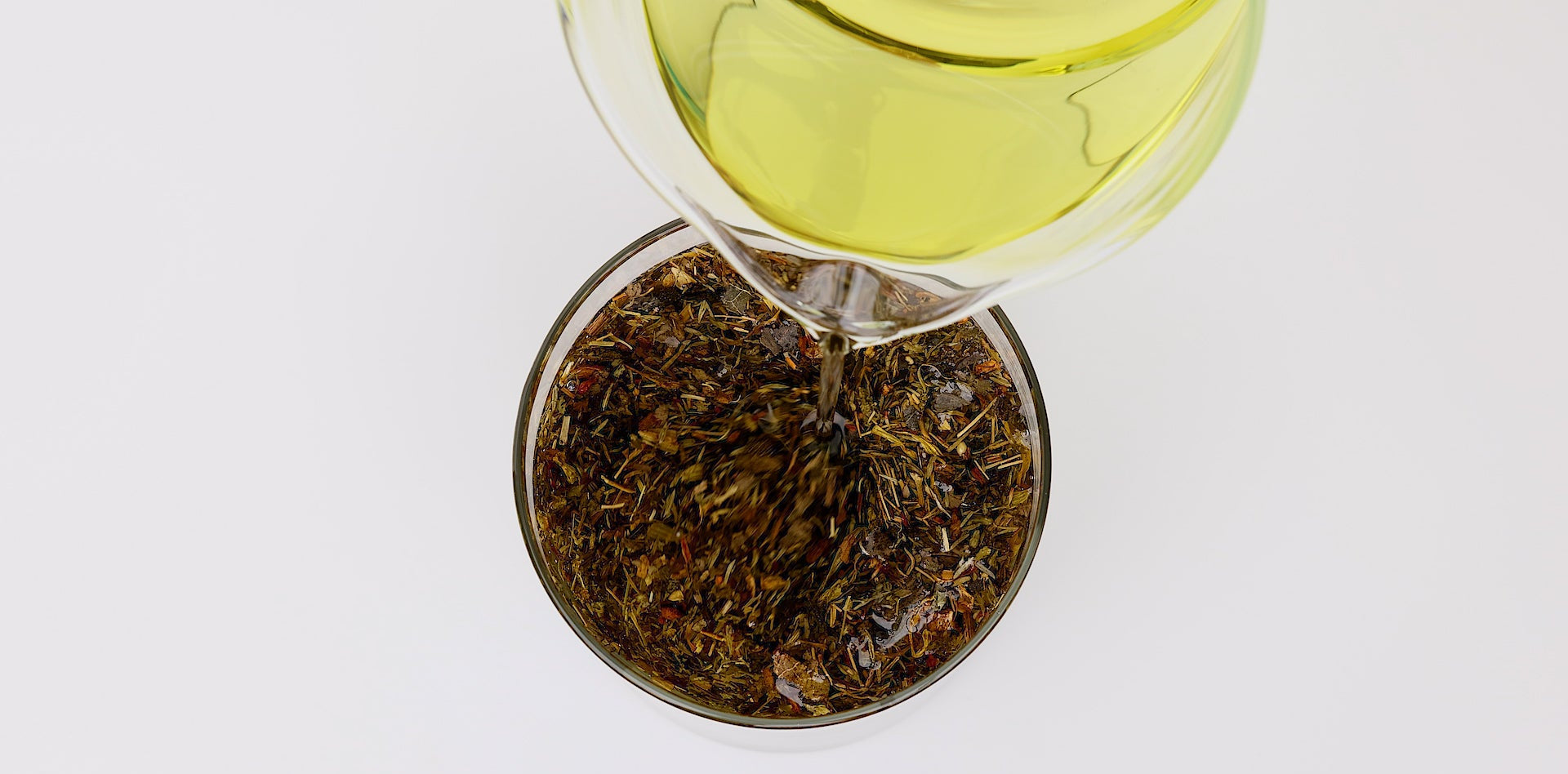 The Amazing Benefits of Pure Grapeseed Oil For the Skin Blog Post Grapeseed Oil Pouring into Herbs